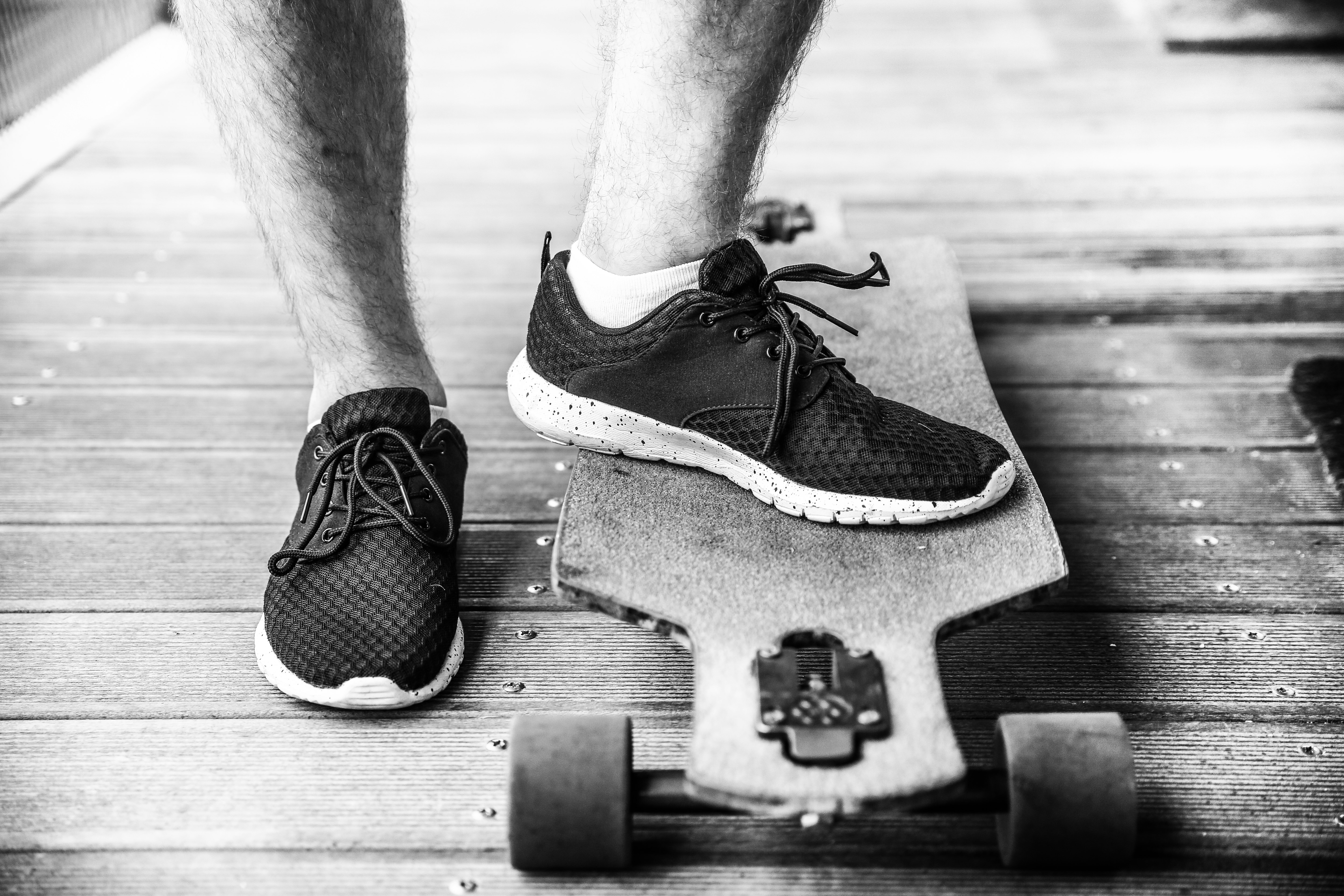 grayscaled photography of person on longboard